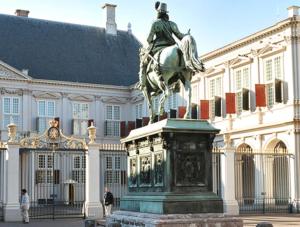 een standbeeld van een man op een paard voor een gebouw bij ADAM & EVE Paleisstraat in Den Haag