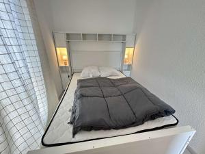 a bed in a small room with two pillows at Appt Studio 2 couchages CAP D'AGDE CT121-022 in Cap d'Agde