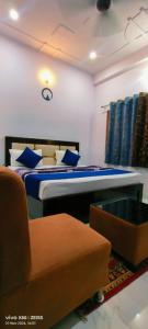a bedroom with a bed and a chair and a clock at Hotel Prince palace in Ayodhya