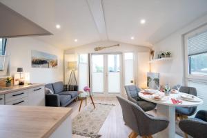 シャルボイツにあるOstseecamp Ferienhaus Lily Pondのテーブルと椅子のあるキッチンとリビングルーム