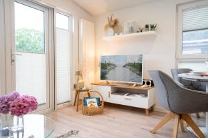 シャルボイツにあるOstseecamp Ferienhaus Lily Pondのリビングルーム(テレビ、デスク、椅子付)
