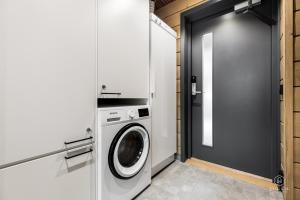 een wasruimte met een wasmachine en een deur bij Levin Lyhty Bea by Hilla Villas in Kittilä +34 foto's