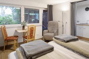 a room with two beds and a chair and a window at Ferienwohnung Tuniberg in Umkirch