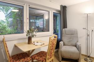 a dining room with a table and a chair and a window at Ferienwohnung Tuniberg in Umkirch +18 photos