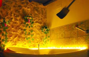 a bathroom with a tub with lights on the wall at Valle del jerte el huerto del cura in Cabezuela del Valle