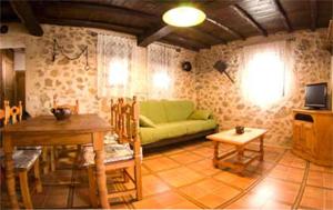 un salon avec un canapé vert et une table dans l'établissement Valle del jerte Apartamento Con Hidromasaje, à Cabezuela del Valle