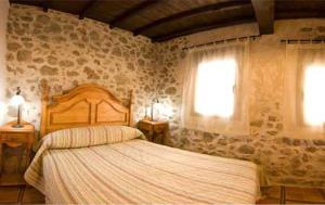 une chambre avec un grand lit et deux fenêtres dans l'établissement Valle del jerte Apartamento Con Hidromasaje, à Cabezuela del Valle