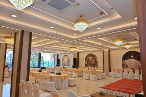 a banquet hall with tables and chairs and chandeliers at The EcoXpress Satva Varanasi - Vegetarian with all Options in Varanasi