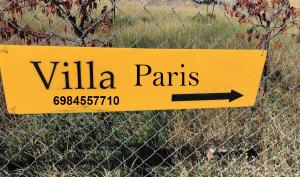 a yellow sign that says villa pens on a fence at Arachova Villa Paris in Kalívia