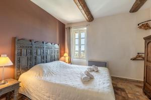 Un dormitorio con una cama grande con toallas. en Le Chef d'Escadron, en Bonnieux 14 fotos más