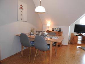 a dining room with a wooden table and chairs at Ferienwohnung MeerMoment in Wangerland +8 photos