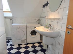 a bathroom with a washing machine and a sink at Ferienwohnung MeerMoment in Wangerland