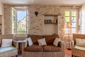 Una sala de estar con un sofá y sillas y ventanas. en Le Chef d'Escadron, en Bonnieux