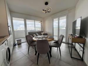 un salon avec une table, des chaises et une télévision dans l'établissement Appartement Standing 3 pièces CAP D 'AGDE CT037-053, au Cap d'Agde