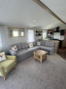 a living room with a couch and a table at Fantasy Island - Eastgate E6 - The Sierra with Hot Tub - Coastal Caravan Breaks in Ingoldmells