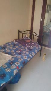 a bed with a blue comforter with flowers on it at Lakeside in Mumbai +5 photos