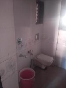 a bathroom with a toilet and a trash can at Lakeside in Mumbai