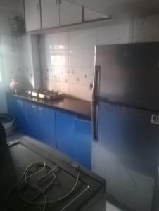 a kitchen with a refrigerator and a counter top at Lakeside in Mumbai