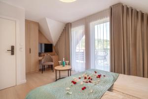Un dormitorio con una cama con rosas. en Willa Ponikiewka, en Międzybrodzie Bialskie