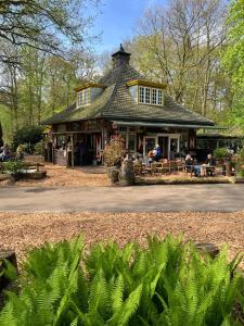 a large building with people sitting outside of it at Bosparel met ruime tuin en airco! in Oisterwijk