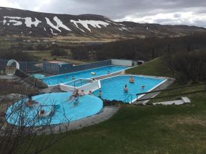 a group of people in a large swimming pool at Harpa Holiday Home - Birta Rentals in Húsafell