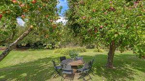 a table and chairs sitting under an apple tree at Lambs Lawn in Coulston