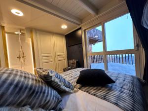 a bedroom with a bed with pillows and a window at Luxury Ski-in and Ski-out Apartment 4 Bedrooms with 4 Baths Val Thorens Emeraude 1 in Val Thorens