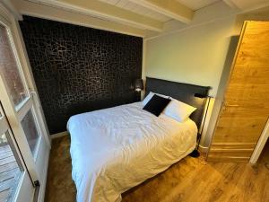 a bedroom with a bed with a black accent wall at Luxury Ski-in and Ski-out Apartment 4 Bedrooms with 4 Baths Val Thorens Emeraude 1 in Val Thorens +14 photos