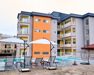 an apartment building with chairs and a swimming pool at Résidence meublée kribi in Kribi