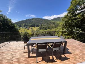 einen Tisch und Stühle auf einer Terrasse mit Aussicht in der Unterkunft Le Chantoiseau in Muhlbach-sur-Munster