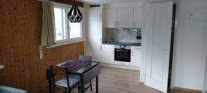 a kitchen with white cabinets and a table and a window at Apartment am See in Murg