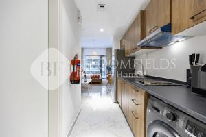 y cocina con lavadora y secadora. en Bloomfields Magnatic STU Oasis Masdar, en Abu Dabi