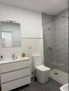 Un baño con inodoro, lavabo y ducha. en Nordés, en Vilagarcía de Arousa