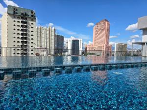 a large swimming pool in a city with tall buildings at Chamber Suites KL At Sky World in Kuala Lumpur