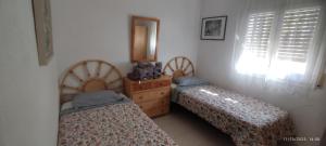a bedroom with two beds and a dresser and a mirror at Casa Jazmin in Roses +9 photos
