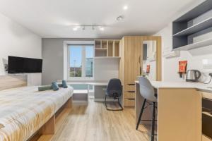 a bedroom with a bed and a desk and a kitchen at Brand New Student Only Studios In Central Leeds in Elland