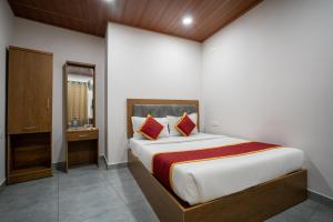 a bedroom with a large bed with red pillows at stay inn hotel in Kozhikode