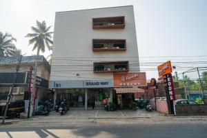 a white building with motorcycles parked in front of it at stay inn hotel in Kozhikode