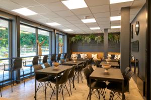 a dining room with tables and chairs and windows at Horten Apartment in Horten