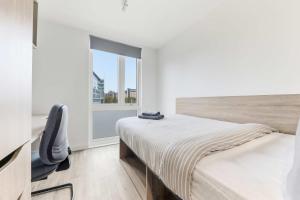 a bedroom with a bed and a chair and a window at Brand New Ensuite Rooms In Central Leeds in Leeds