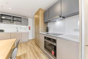 a kitchen with white cabinets and a counter top at Brand New Ensuite Rooms In Central Leeds in Leeds