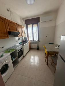 una cucina con lavatrice e tavolo di Valentin Monfalcone Apartment near Fincantieri and Marina Julia a Monfalcone
