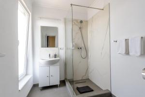 a white bathroom with a shower and a sink at Villa Cristian in Arad