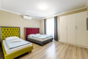 a bedroom with two beds and a large window at Villa Cristian in Arad +11 photos