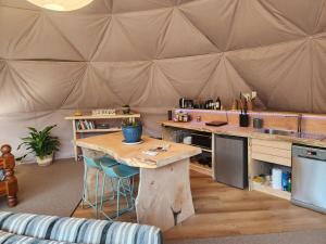 LivingstoneにあるDanseys Pass Lavender Farm Retreatの木製のテーブルとカウンターのある大きなテント