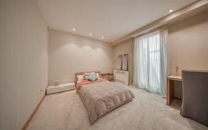 a bedroom with a bed and a desk and a window at Zvezdopad in Sheremetler