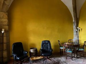 tavolo e sedie in una stanza con parete gialla di Chateau d Albon a Saint-André-dʼApchon