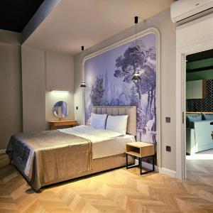 une chambre avec un grand lit avec un tableau au mur dans l'établissement Mardan Bro, à Baku