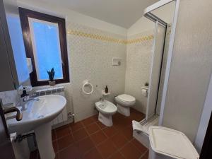 a bathroom with a sink and a toilet and a window at Grigna Roberta s Lodge - Wi-Fi Gratuito in Civenna +24 photos