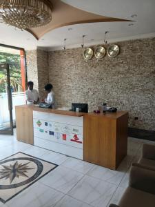 dos personas de pie en un mostrador en una habitación en Kitsel Hotel, en Bahir Dar